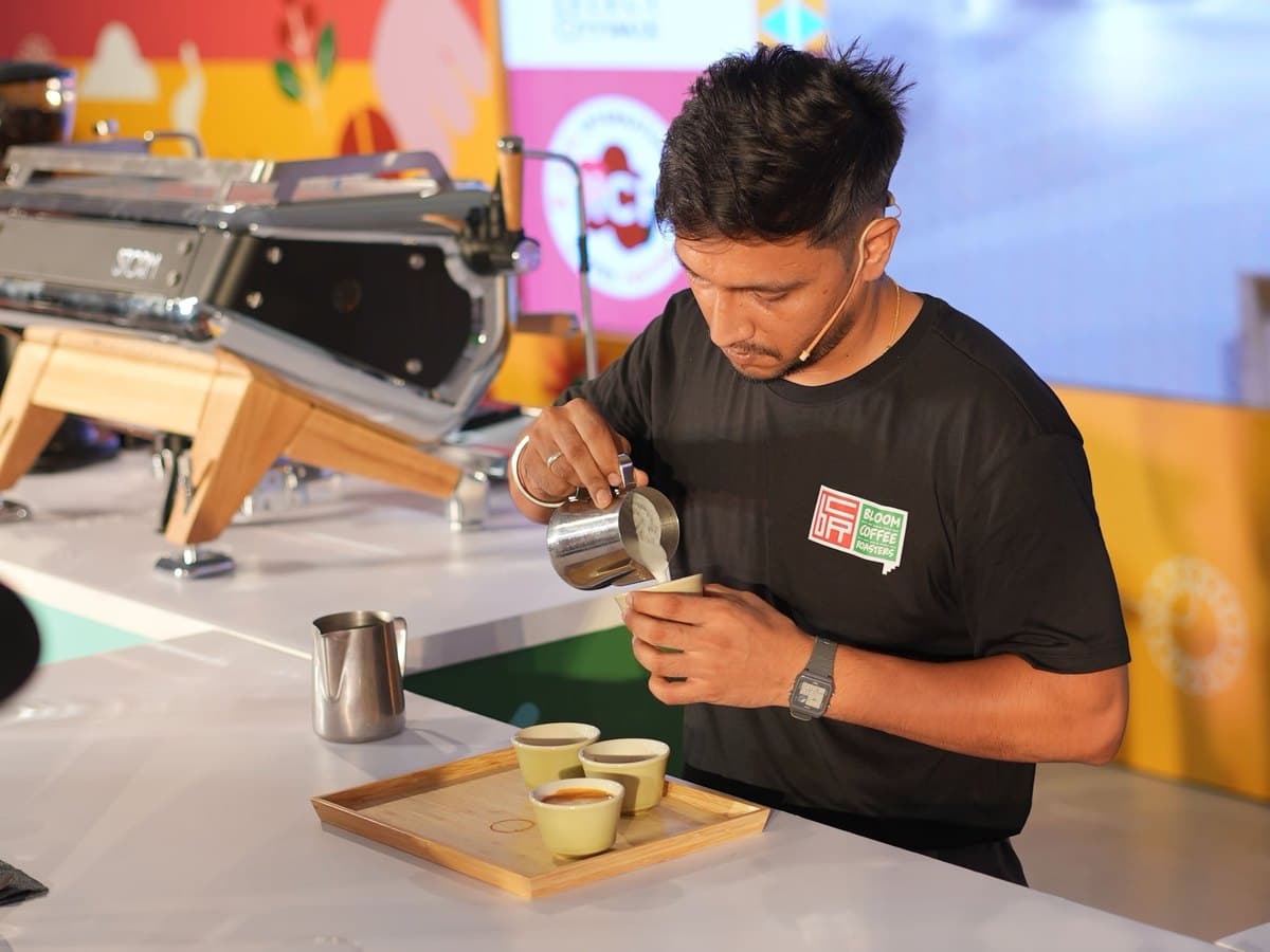 A competitor pouring milk into tasting cups on the competition bench