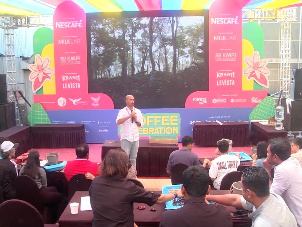 A speaker leading a hands-on session with participants at tables